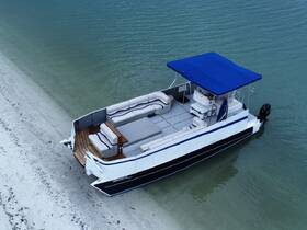 Aerial view of a stylish pontoon boat docked on a sandy shore, showcasing its spacious seating and inviting design, perfect for leisurely outings on the water.