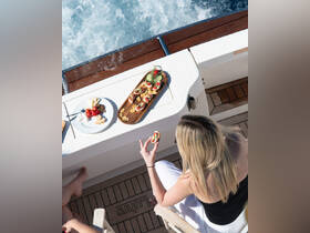 A beautifully arranged platter of snacks and drinks is enjoyed on a boat, perfect for a luxurious day at sea.