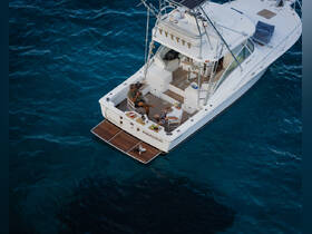 Two friends enjoy a relaxing moment on the deck of the 'Miracolo' boat, surrounded by the beautiful ocean, perfect for fishing trips or leisurely days on the water.