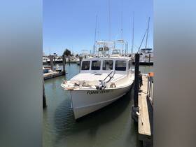A clear view of the 'Fishin' Fever IV' fishing boat docked at the marina, showcasing its structure and design, perfect for fishing enthusiasts.