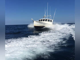 A dynamic shot of the 'Fishin' Fever IV' speeding through the waves, showcasing its sleek design and performance on the open water.