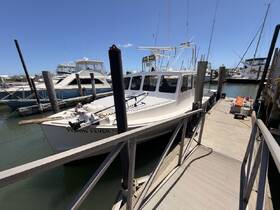 A fishing boat named 'Fishin Fever' docked at the marina, showcasing its sleek design and readiness for a day on the water.