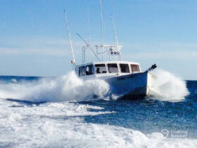 A dynamic shot of the fishing boat 'Fishing Fever IV' cutting through the waves, showcasing its speed and agility on the open water.