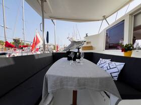 A beautifully arranged dining area on a yacht, featuring a table set with champagne and elegant decor, perfect for intimate gatherings or sunset dinners on the water.