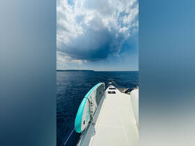 A scenic view from the side of a boat featuring a paddleboard, with a stunning backdrop of clouds and calm waters, perfect for a day of adventure on the sea.