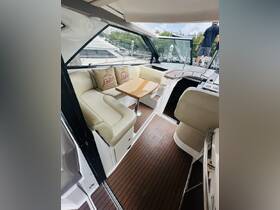 A cozy interior view of a boat's lounge area featuring comfortable seating and a table, perfect for relaxing while enjoying the water.
