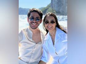 A cheerful couple enjoys a sunny day on the boat, capturing a perfect moment against a stunning ocean backdrop.