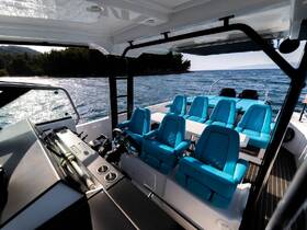 A spacious interior view of a modern boat's helm and seating area, featuring comfortable blue seats and a sleek design, perfect for a day on the water.