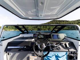 A sleek view of the helm and console inside a modern boat, showcasing the advanced navigation equipment and stylish design, perfect for a day on the water.