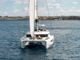A sleek catamaran sails through clear waters with guests on board, showcasing the perfect setting for a memorable sailing adventure.