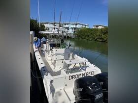 A group prepares for a fishing trip aboard the 'Drop N' Reel' boat, showcasing the excitement of a day on the water in a scenic location.