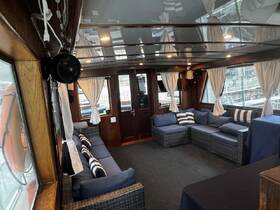 Cozy interior of a boat featuring comfortable seating and large windows, perfect for relaxing while enjoying the views on the water.