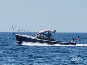 A speedboat glides through the water with passengers onboard, showcasing a perfect day for boating adventures.