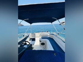 Interior view of a boat's helm and seating area, showcasing comfortable seating and a clear view of the tranquil waters ahead.