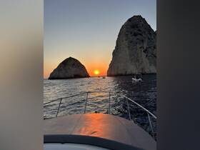 A stunning sunset view from the bow of a boat, framed by dramatic coastal rock formations — perfect for capturing the beauty of evening cruises.