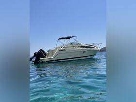 A sleek motorboat glides through crystal-clear waters under a bright blue sky, showcasing its elegant design and perfect for a day on the water.