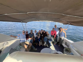 A lively group of friends enjoys a fun day on the boat, capturing memories and celebrating together on the water.