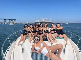 A lively group of friends enjoys a sunny day on a boat, showcasing fun and celebration on the water — perfect for summer outings and gatherings.