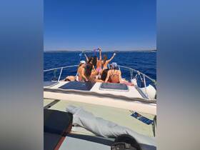 A lively group of friends enjoys a sunny day on the boat, celebrating with drinks and laughter against a stunning ocean backdrop.