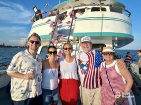 A cheerful group of friends celebrates aboard a decorated boat, enjoying a festive atmosphere on the water.