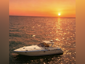 A stunning aerial view of a sleek boat cruising on the water at sunset, creating a picturesque scene perfect for romantic getaways or scenic tours.