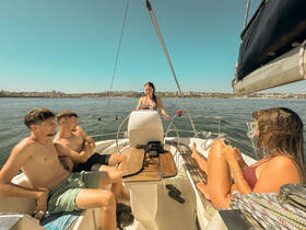 A group of friends enjoys a sunny day sailing, capturing the essence of summer fun on the water. Perfect for showcasing memorable sailing experiences.