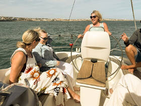 A joyful group of friends enjoys a sailing experience, with laughter and camaraderie on the deck of a boat, perfect for creating unforgettable memories on the water.