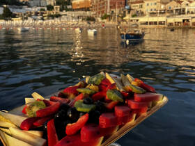 A vibrant platter of fresh fruit displayed on a boat, perfect for enjoying while cruising on the water. Ideal for catering or snack options during a day out at sea.