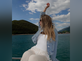 A woman enjoys the beautiful scenery while relaxing on a boat, capturing the essence of a perfect day on the water.