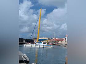 A vibrant catamaran sails through the harbor, with guests enjoying the scenic views — perfect for a day of adventure on the water.