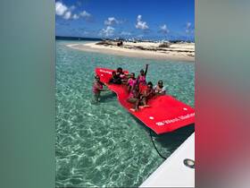 A lively group of friends enjoys a fun day at the sandbar, lounging on a floating mat in crystal-clear waters — perfect for summer celebrations and beach outings.