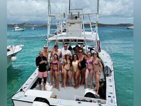 A lively group of friends poses on the deck of a boat, enjoying a fun day on the water — perfect for celebrations and memorable outings.