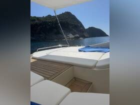 A serene view of the lounge area on a boat, featuring comfortable seating and a backdrop of rocky hills, perfect for relaxing while enjoying the water.