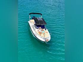 Two friends relax on a boat in turquoise waters, enjoying drinks and sunshine — the perfect setting for a day of leisure on the water.