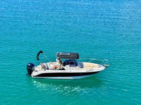 A couple relaxes on a sleek boat in vibrant turquoise waters, perfect for a day of leisure and adventure on the sea.