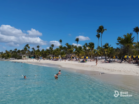 A vibrant beach scene with people enjoying the clear waters and sunny weather, perfect for a relaxing vacation getaway.