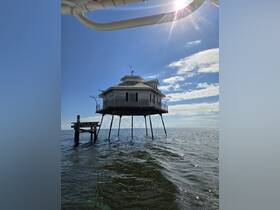 A unique structure stands over the water, but the image lacks clarity and detail, making it difficult to identify the subject.
