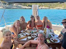 A joyful group of friends enjoys a delicious meal aboard a boat, capturing the essence of a fun-filled day on the water.
