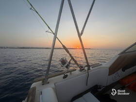 A serene sunset view from the deck of a boat, featuring a fishing rod, perfect for evening fishing trips or relaxing on the water.
