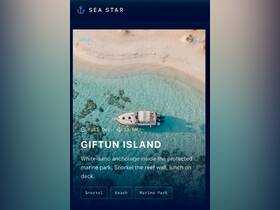 Aerial view of a boat anchored in the clear waters of Giftun Island, showcasing a pristine white-sand beach and vibrant marine life, perfect for snorkeling adventures.