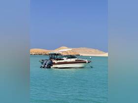 A sleek speedboat is docked in tranquil turquoise waters, surrounded by sandy hills — perfect for a day of relaxation on the water.