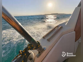 A stunning view from the side of a boat cruising through sparkling waters, with the sun setting in the background, perfect for showcasing the beauty of a day on the water.