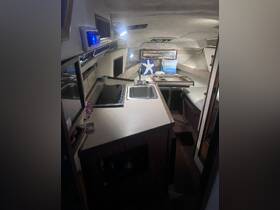 Interior view of a boat's cabin featuring a well-equipped kitchen area, showcasing the cozy and functional design ideal for onboard living.