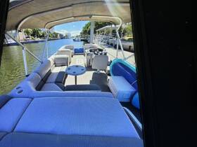 Interior view of a spacious pontoon boat featuring comfortable seating and a well-equipped helm, perfect for relaxing on the water.