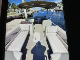 Interior view of a spacious pontoon boat featuring comfortable seating and a helm, perfect for relaxing on the water.