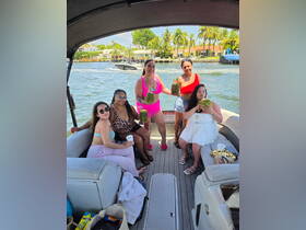 A vibrant group of friends enjoys a fun day on a pontoon boat, celebrating with tropical cocktails in hand — perfect for summer parties on the water.