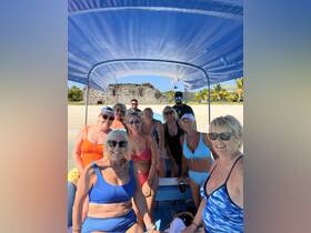 A lively group of friends enjoys a fun day on a boat, ready for beach adventures and memorable moments under the sun.