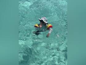 A child enjoys swimming in crystal-clear waters, showcasing a fun and safe aquatic experience perfect for family outings.