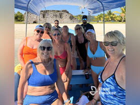 A lively group of women enjoys a fun day on the water, posing together on a boat with a beautiful beach backdrop — perfect for memorable outings and celebrations.