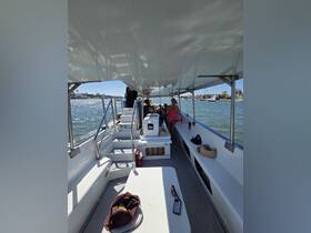 Interior view of a boat's cabin with guests seated and enjoying the ride — a perfect space for relaxation and socializing while on the water.